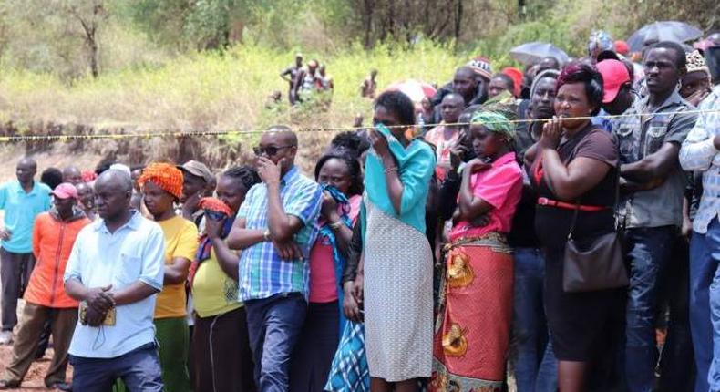 Residents watch the exhumation of the body of murdered priest