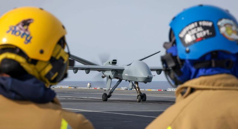 Royal Navy sailors watch as the Mojave unmanned aircraft lands on HMS Prince of Wales for the first time in history.UK Royal Navy