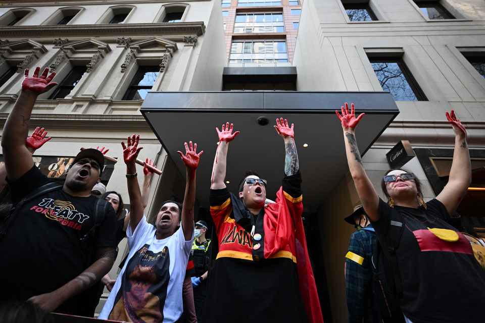 Protestujący unieśli pokryte farbą ręce przed brytyjskim konsulatem podczas protestu antymonarchicznego w Melbourne
