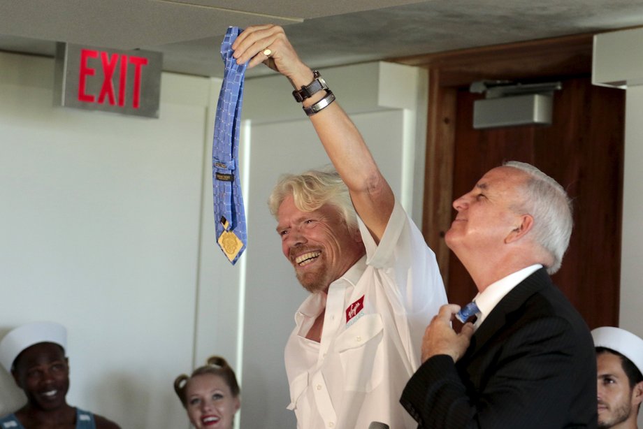 Virgin Group founder Richard Branson holds the tie he cut off Miami-Dade county Mayor Carlos A. Gimenez in 2015.