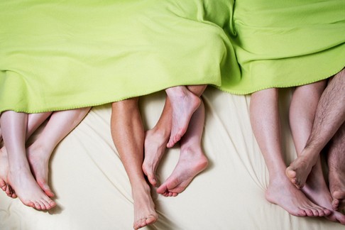 Low Section Of People In Bed