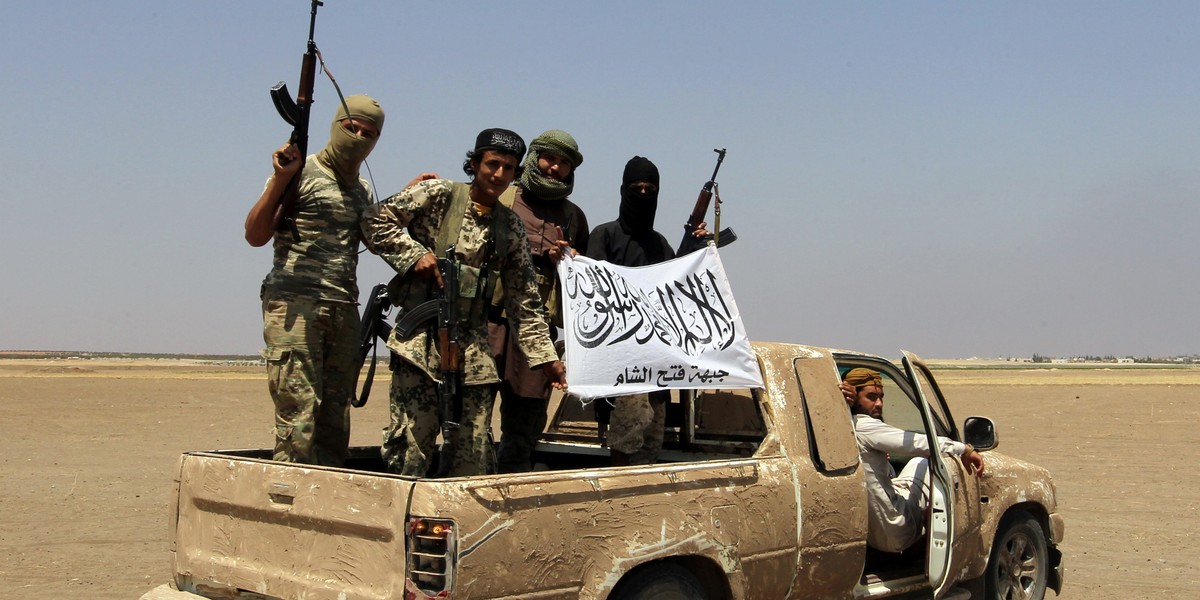 Fighters of the Syrian Islamist rebel group Jabhat Fateh al-Sham cheer on a pick truck after a Russian helicopter had been shot down in the north of Syria's rebel-held Idlib province, Syria, August 1, 2016.