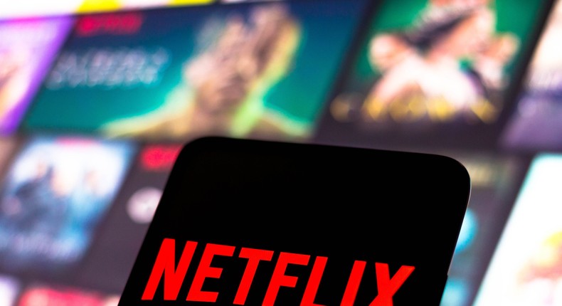 The Netflix logo is displayed on a smartphone screen.