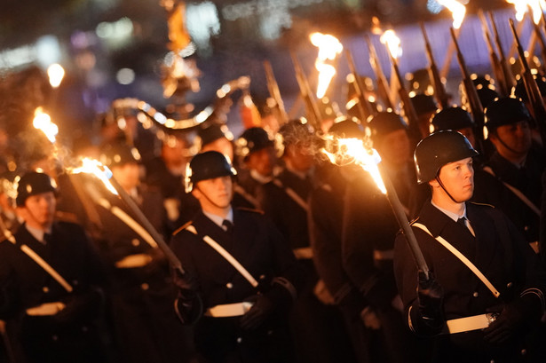 Niemieccy żołnierze maszerują z pochodniami przed Reichstagiem