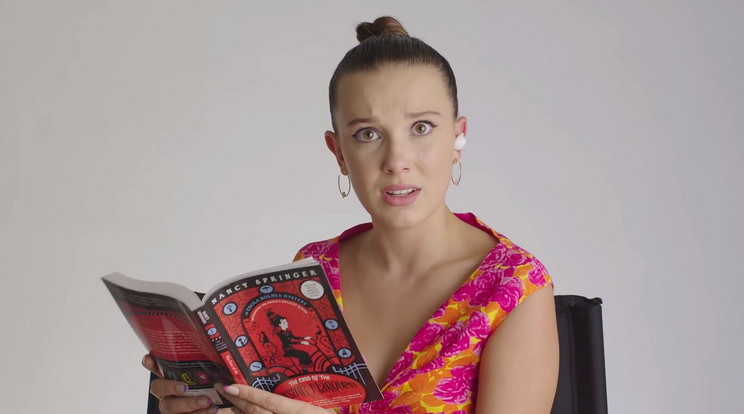 Millie Bobby Brown éppen az egyik Enola Holmes-könyvből olvas fel, melynek filmes adaptációjában a főszerepet játszotta a fiatal színésznő / Fotó: Netflix