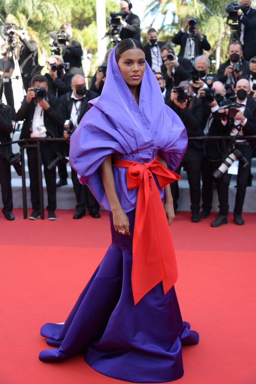 Model Tina Kunakey (24) zieht auf dem roten Teppich Model in einem farbenfrohen Seiden-Look von Maison Valentino alle Blicke auf sich. 