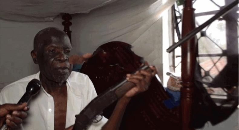 NRA veteran Musa Mwanje holding his firearm