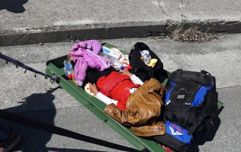 Walizka syryjskiego uchodźcy na greckiej wyspie Lesbos, w środku śpi dziecko...