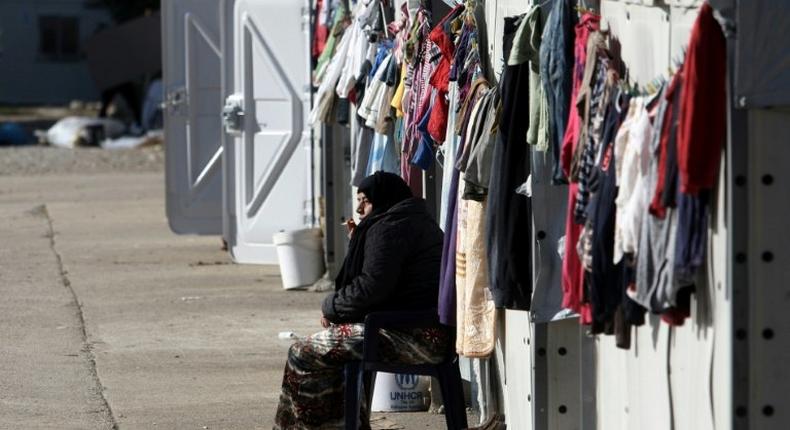 A woman smokes a cigarette at a refugee camp in Thessaloniki