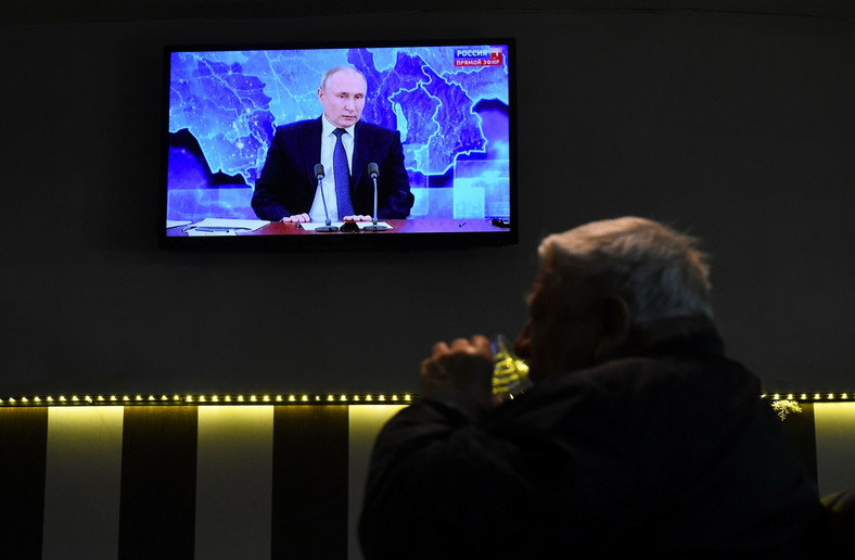 Mężczyzna w petersburskim barze ogląda wystąpienie Władimira Putina [grudzień 2020 r.]