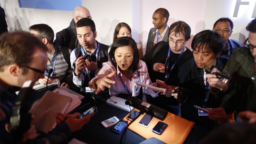 Dziennikarze oglądają smartfon ZTE Open, działający na systemie operacyjnym Firefox