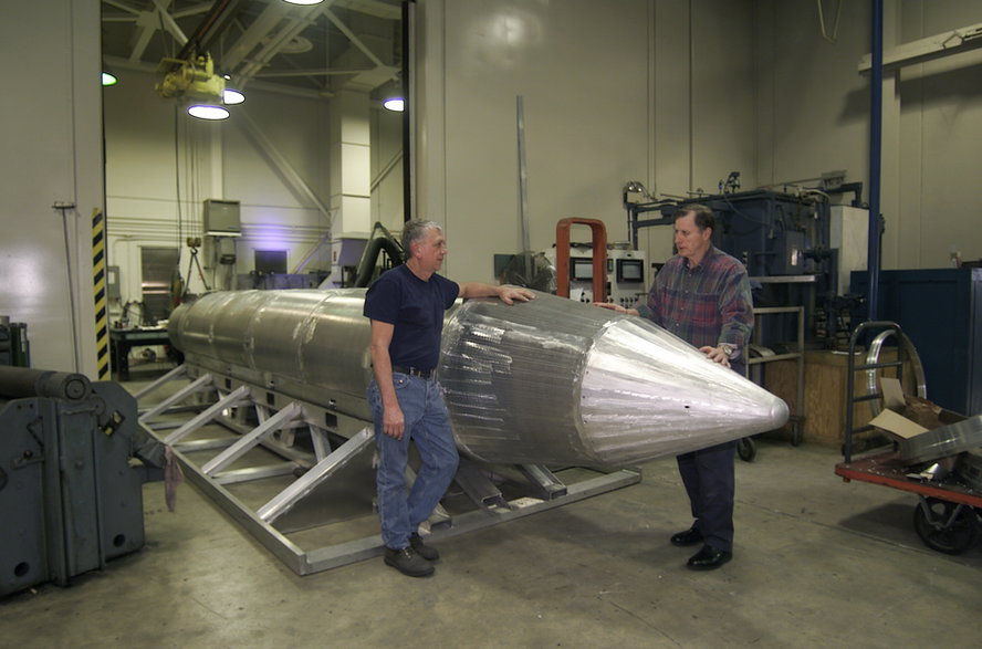 Konstruktor Al Weimorts (z lewej) i szef zespołu prototypowego Joseph Fellenz przy prototypie bomby GBU-43/B MOAB, jeszcze przed jej pomalowaniem. Bomba ma aluminiowy korpus z głowicą bojową BLU-120/B zawierającą 8480 kg materiału wybuchowego.