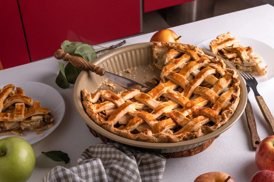 Homemade cutting Apple Pie with fresh apples on white kitchen table, ready to eat