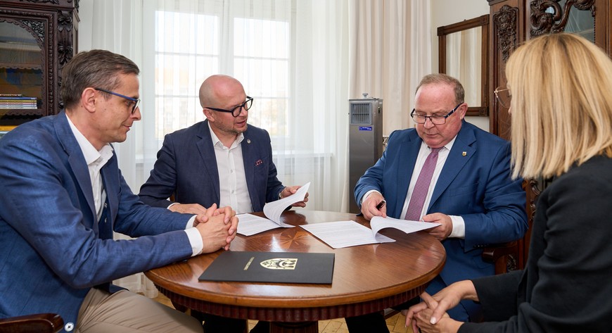 Wiceprezydent Jakub Mazur (z lewej) i starosta Włodzimierz Chlebosz (drugi z prawej) podpisują stosowne dokumenty.