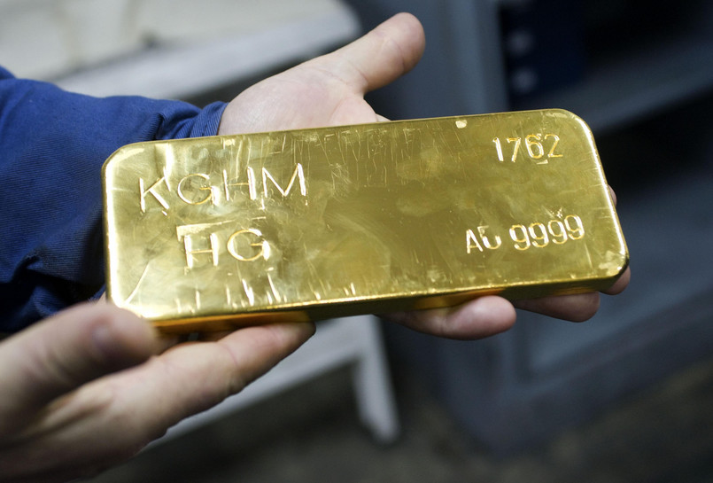 Robotnik trzyma sztabkę złota w hucie KGHM w Głogowie
