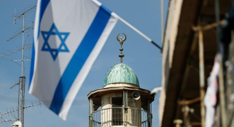 An Israeli flag is pictured in front of the minaret of a mosque in the Arab quarter of Jerusalem's Old City on November 14, 2016 Israeli Prime Minister Benjamin Netanyahu said he backed a bill limiting the volume of calls to prayer from mosques, a proposal government watchdogs have called a threat to religious freedom.