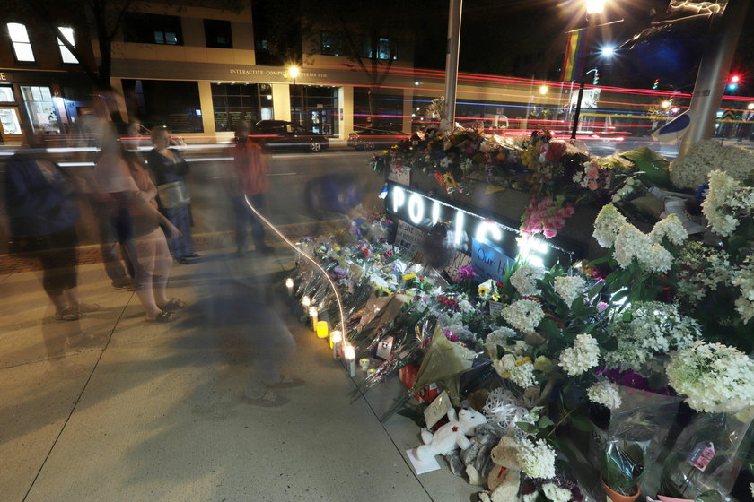 Fredericton residents pay their respects at a makeshift shrine in front of police headquarters