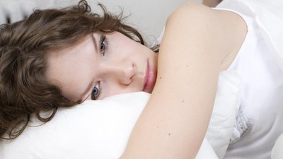 brunette curl woman lying on the bed