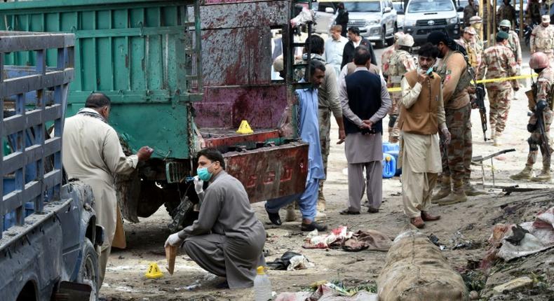 Pakistani security officials inspect the site of a bomb blast at a fruit market in Quetta