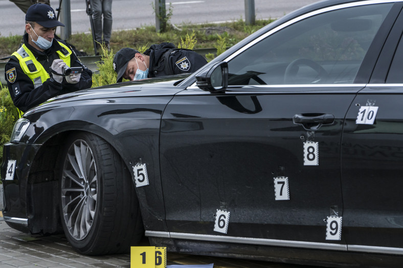 Ukraińscy policjanci oglądają ostrzelany samochód Serhija Szefira. Numery oznaczaja kolejne dziury po kulach. Kijów, 22 września 2021 r. 