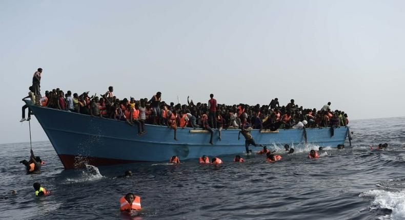 Migrants wait to be rescued in the Mediterranean Sea about 12 nautical miles north of Libya on October 4, 2016