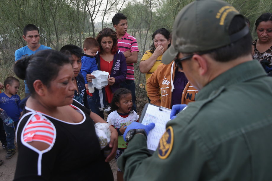 Immigrants from Central America answer questions from a US border patrol agent after crossing the Rio Grande from Mexico into the US on July 24, 2014, near Mission, Texas.