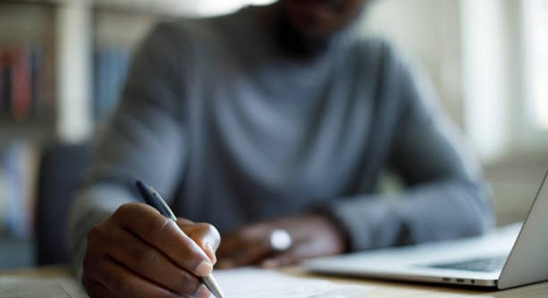 A Black person writing [iStock]