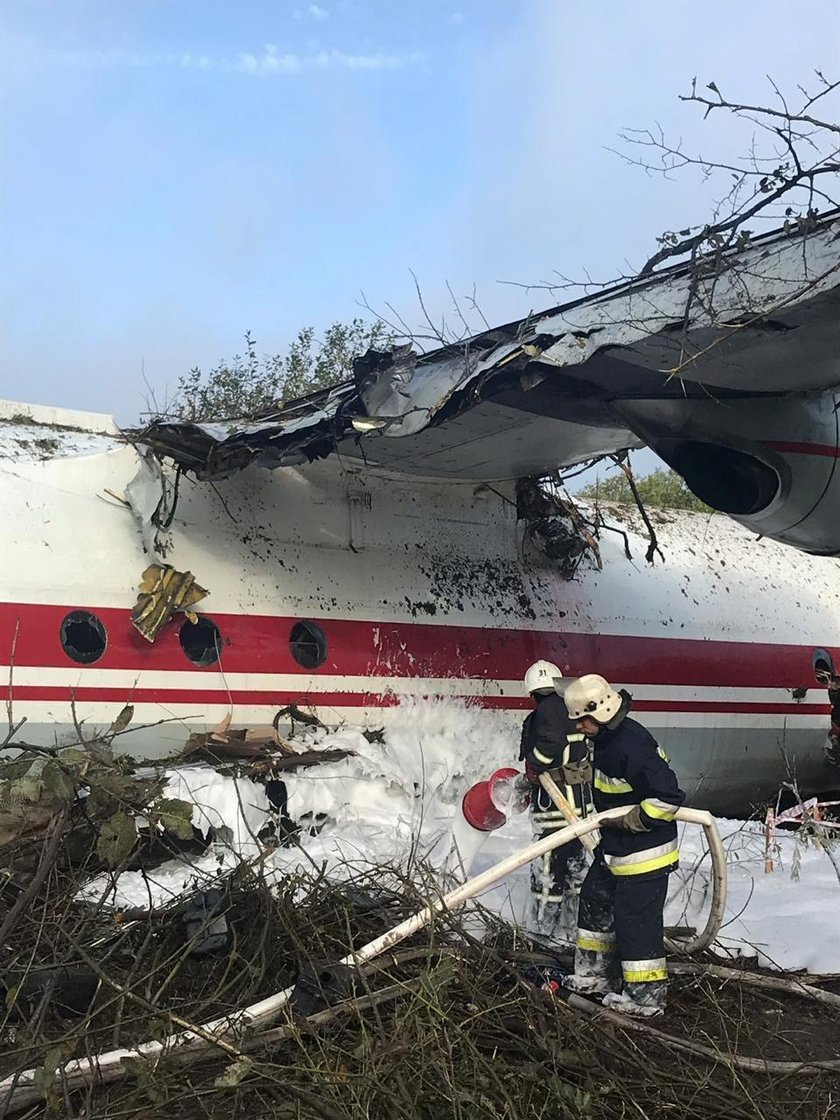 Members of emergency services evacuate a wounded person at the site of the Antonov-12 cargo airplane