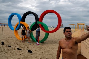 Man takes a selfie in front of the Olympic Rings, displayed at the Copacabana beach ahead of the 201