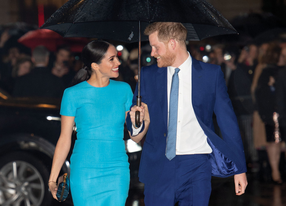 Meghan i Harry spoglądają sobie w oczy i szeroko się uśmiechają