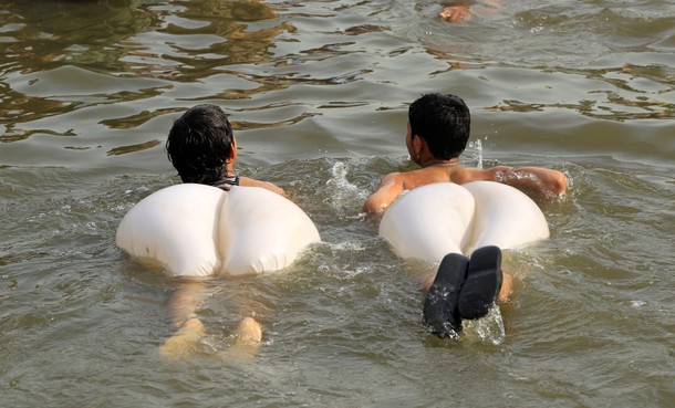 Boys swim in a stream during a heatwave in Islamabad