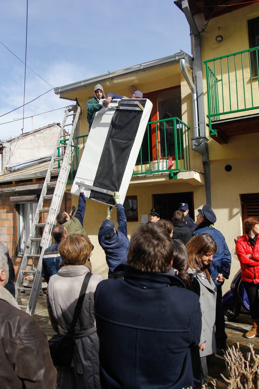 Radnici iznose nameštaj pre početka rušenja