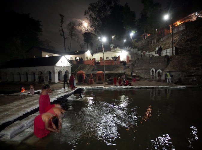 Kobiety o świcie kąpią się w rzece Salinadi w czasie obchodów święta Madhav Narayan w Sankhu, starożytnej wiosce niedaleko Katmandu