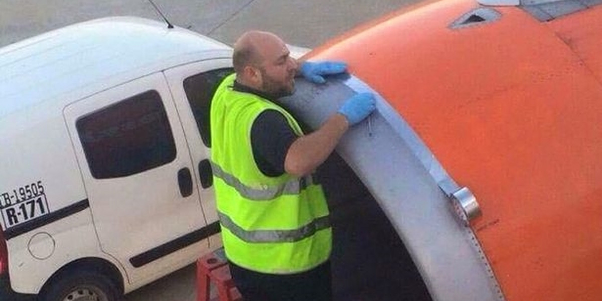 Pracownik naprawia samolot taśmą klejącą przed startem