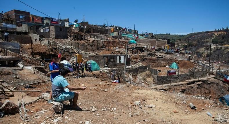 Local residents live in tents while they work to rebuild after the damage caused by the January 2 forest fire in Puertas Negras, Valparaiso, Chile, on January 12, 2017