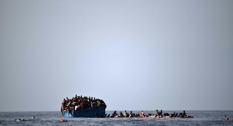 Migrants wait to be rescued by members of Proactiva Open Arms NGO in the Mediterranean Sea, some 12 nautical miles north of Libya, on October 4, 2016