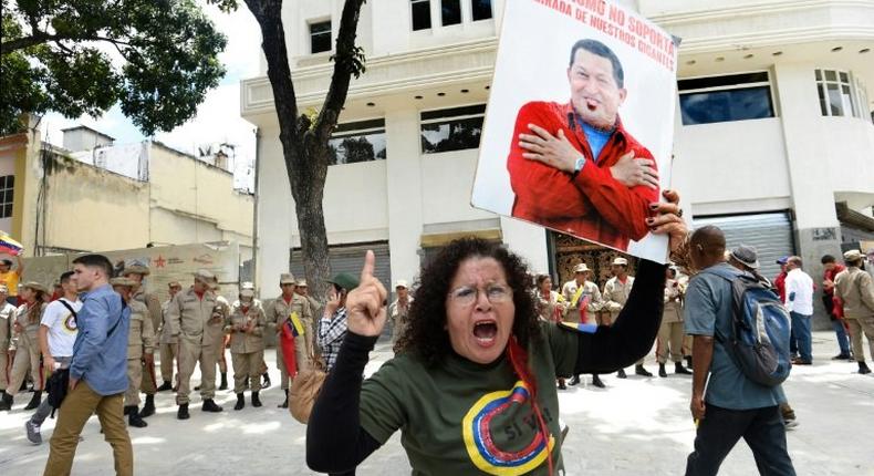 A government supporter holding a picture of late Venezuelan leader Hugo Chavez shouts slogans in favor of the new Constituent Assembly, which began work on Friday