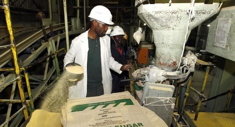 A worker weighs and packs bags of sugar at the Mumias sugar factory in western Kenya February 24, 2015. REUTERS/Thomas Mukoya