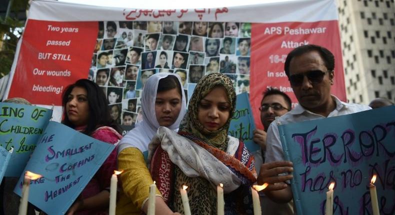 Residents of Karachi hold lighted candles during a ceremony on December 16, 2016, as they pay tribute to victims on the second anniversary of an attack on The Army Public School in the northwestern city of Peshawar Parents of children killed when Taliban gunmen overran a Pakistan school have gathered to mark the second anniversary of the attack, just days after another youngster died from his wounds. More than 150 people -- mostly students -- perished when heavily-armed men raced through the Army Public School in Peshawar on December 16, 2014, firing indiscriminately.