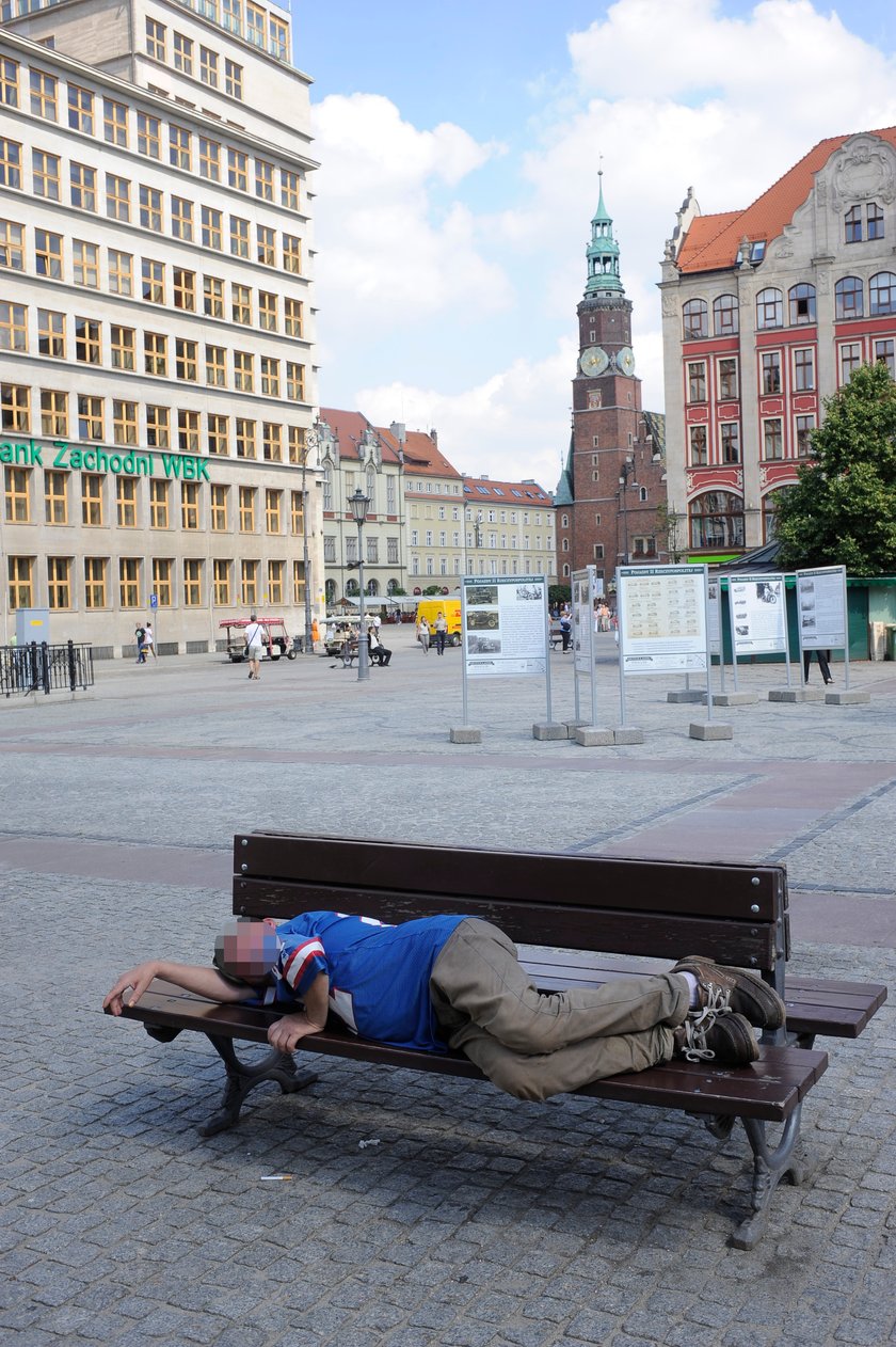 Bezdomny śpi na ławce na pl. Solnym