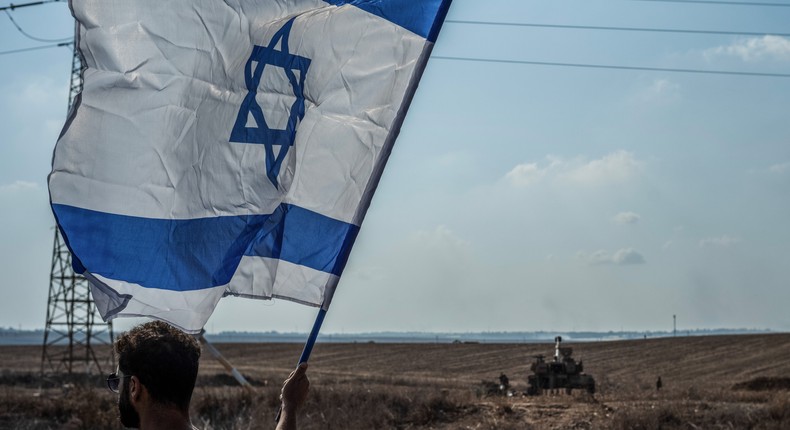 Man holding Israeli flag on October 11, 2023.Ilia Yefimovich/picture alliance via Getty Images