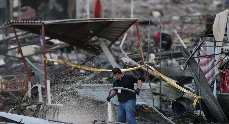 A man uses a water hose after an explosion at the San Pablito fireworks market outside the Mexican capital on Tuesday, in Tultepec, Mexico, December 20, 2016.