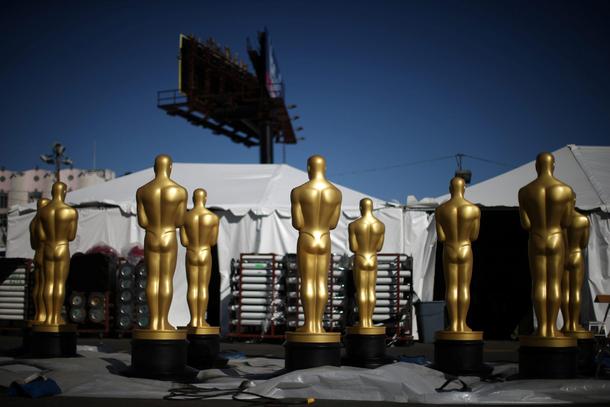 Freshly-painted Oscar statues sit in a parking lot outside the Dolby Theatre as preparations continu