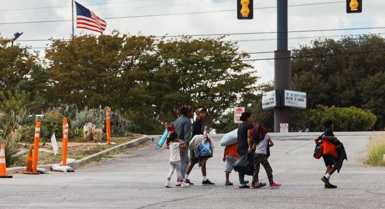 A groups of migrants walk from the Migrant Resource Center to a nearby shopping center in search of food on September 19, 2022 in San Antonio, Texas.