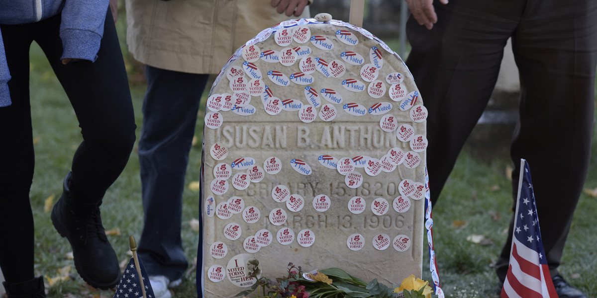 Hundreds line up to pay their respects at Susan B. Anthony's grave, leaving their 'I Voted' stickers for Hillary Clinton