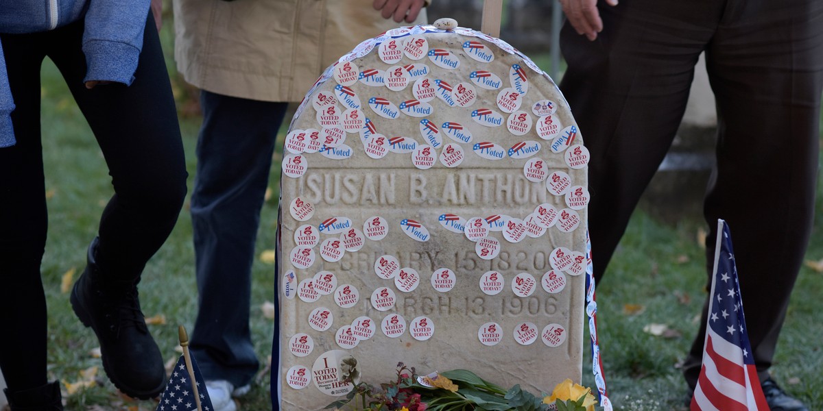 Hundreds line up to pay their respects at Susan B. Anthony's grave, leaving their 'I Voted' stickers for Hillary Clinton