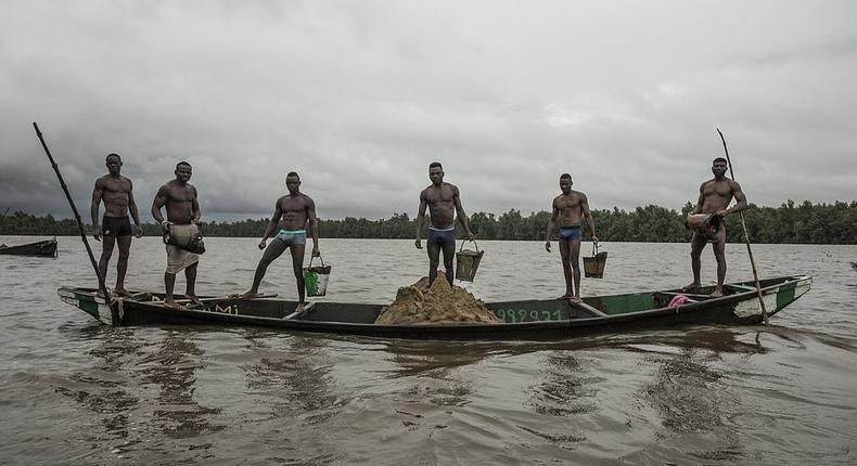 Cameroonian artisanal miners go diving in the Wouri river an average of 100 times a day for wet sand [Hugh Brown/SWNS.com]