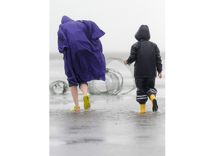 Niemcy, turyści zmagaja się z wiatrem i deszczem nad Morzem Północnym w pobliżu Cuxhaven