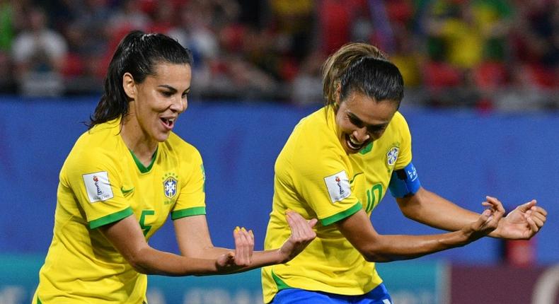 Marta (right) celebrates her record-breaking goal with midfielder Thaisa