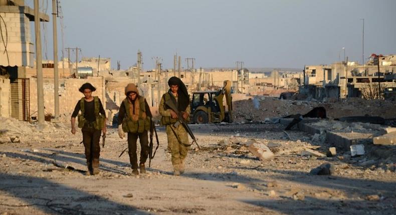 Turkish-backed Syrian rebels patrol through the town of al-Bab shortly after they captured it from the Islamic State (IS) group